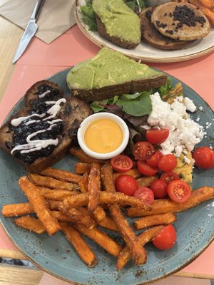 Vegan brunch plate: chickpea omelette, feta cheese and cherry tomatoes / avocado toast and sweet potato fries with harissa mayo / banana bread with coconut yogurt and blueberry jam at Shake Cafe - Camillo Cavour in Florence