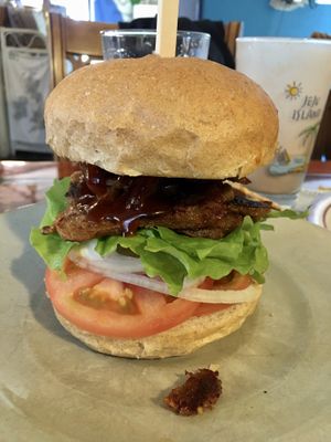 Vegan bulgogi burger made with grilled seitan slices and topped with housemade veganaise, pickled jalapeño, tomato, lettuce and onions  at And 유 (Yu) Cafe in Jeju