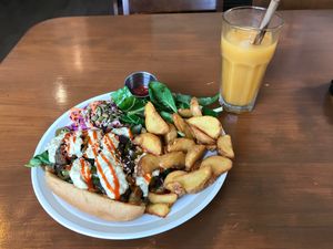 Vegan cheesesteak sandwich with wedges, salad, slaw and organic Jeju mandarin juice  at And 유 (Yu) Cafe in Jeju