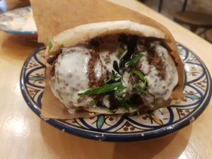 Falafel sandwich with grilled aubergines and a variety of other vegetables and different sauces at Levantine in Paris