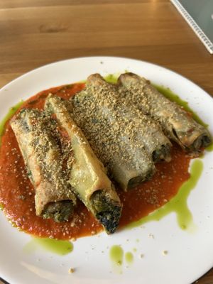 
Ofengebackene Cannelloni, gefüllt mit würzigem Käse, frischem Spinat und Champignons. Serviert mit einem hausgemachten Dip. (vegan)  at Schadzi Cafe in Linz