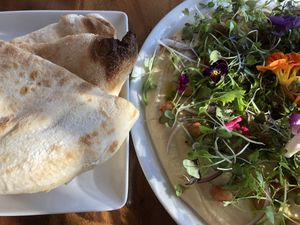 Hummus and flat bread aka delicious soft pizza and a bad ass plate of hummus topped with greenery and florals - it’s ‘uge!! at Due South in Albany