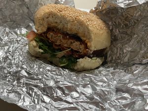 Vegan burger "Veganski pohancek" with wheat flour based bombette with pumpkin oil and pumpkin seeds, fried tofu, tomato, arugula, vegan mayo.  at Bullizza in Ljubljana