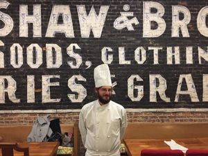 Chef Max fuzzily standing in front of the 1895 original advertisement in Damfino's, discovered when the wall was taken down during renovations.  at Damfino's in Quincy