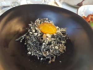 Charcoal bucatini with smoked mushroom pancetta, vegan egg yolk and plant based parmesan at Mark & Vinny's Spaghetti & Spritz in Surry Hills