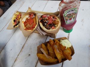 Three servings: the red, yellow and kebab dishes, and french fries. at Cookoomela Grill in Athens