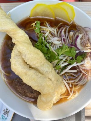 very custom homemade pho soup, with meat like pieces, noodles and veggies, served with langoš-like pastry  at Dvanast Dusi in Bratislava