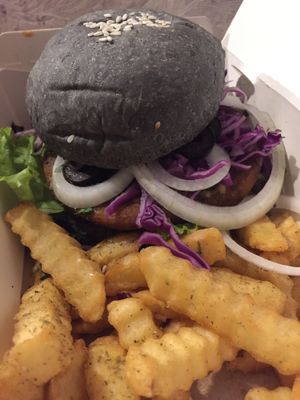 My custom vegan burger creation with amazing fresh crinkle cut fries. I went with the chickpea patty, charcoal bun, herb spread, greens, cabbage, tahini sauce... So delish!  at Black House Burgers in Kuta