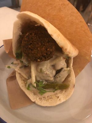 Falafel in pitta with hummus and tahini sauce - doesn’t look big but it was a decent portion with at least 4-5 big sized falafel balls and lots of salad and sauce in between  at Falafeleria - Sta Barbara in Madrid