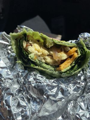 “Garden Breakfast Burrito” sub for vegan eggs and vegan cheddar, with sautéed peppers and onion, spinach and tomatoes.  Choice of sauce.  at City Lights in Sylva