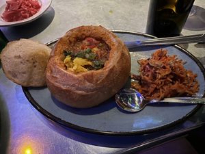 BUNNY CHOW ~ spicy cinnamon-tomato braised chickpea and butternut squash stew burrowed in a crisped sourdough bread bowl served with carrot slaw  at Bang Up To The Elephant in Denver