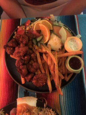 Vegan cauliflour wings with sweet potato fries, salad and fresh fruit at El Castillo in Valkenburg