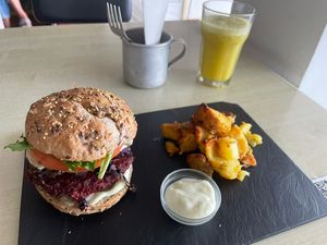 Hambúrguer de beterraba com batata salteada e sumo abacaxi com gengibre  at Kirana Cafe in Peniche