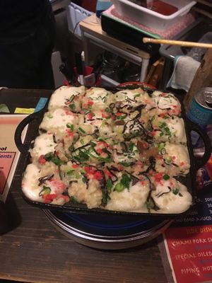 Takoyaki batter with toppings just poured onto the grill at Self Takoyaki Bar IDUCO in Osaka