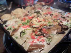 Separating the takoyaki as outside cooked a bit at Self Takoyaki Bar IDUCO in Osaka