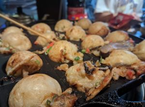 Rotating takoyaki (trying, at least!). at Self Takoyaki Bar IDUCO in Osaka