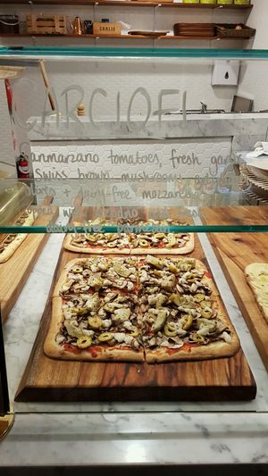 Carciofi pizza with Sanmarzano tomatoes, fresh garlic, swiss brown mushrooms, artichokes, green olives + dairy - free mozzarella. Topped with oregano and fresh dairy-free parmesan. at By GiGi in Miami