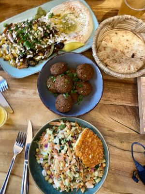 Hummus with grilled veggies, a bowl of falafels and chickpea salad with crispy „schnitzel"  at Hummus Küch' in Frankfurt