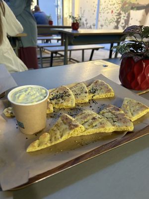 Pie cut in pieces with salt, oregano and olive oil and Tzatziki dip  at Vegan Beat in Athens