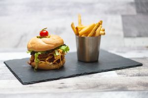 BBQ Beyond Burger w/ Mixed Greens, Tomato, House BBQ Sauce, Vegan Blue Cheese Sauce, Crispy Onion (Gluten Free Options Available) at 97 Street Pub in Kelowna