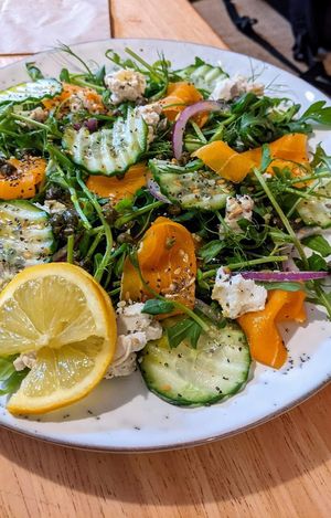 Our popular valmon salad with goat style cheese fresh greens capers lemon oil and omega seeds. at The Garden Cafe and Takeaway in Kendal