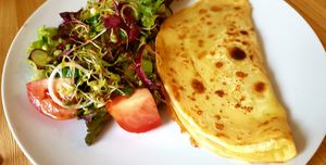 Garbanzo bean crepe with melted "cheese" and choice of relish/pickle dressed side salad and coleslaw. at The Garden Cafe and Takeaway in Kendal
