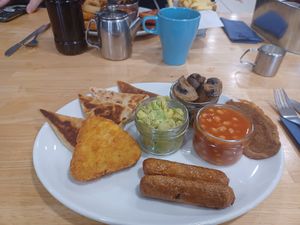 Potato cakes, hashbrown, bacon, sausages, mashed avocado, beans and mushrooms at Causeway Cafe in Belfast