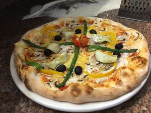 Vegan pizza - vegan cheese, mushrooms, peppers, artichokes, asparagus, olives, tomatoes, almond cooking cream, cashews. at Pizzeria Maxi in Maribor