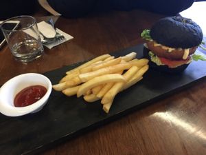 vegan burger in black bun  at Water Drop Vegetarian Cafe in Christchurch