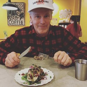 John Roos eating the Rare Roos Burrito at RoosRoast in Ann Arbor