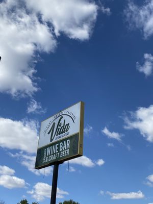 Outside signage with fluffy clouds at Vida Vegan  at Vida Eatery  in Bakersfield