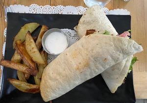 Happy pork wrap: piadina with hand made spicy seitan, salad, tomato, red onion, alioli sauce, mustard and ketchup, with roasted potatoes  at Veg Joy in Rome