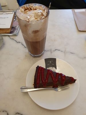 chocolade 'Frambozentaart (vegan) met frambozencoulis' and glass of hot chocomel with whipped cream and marshmallows at Kattencafé Balthazar in Nijmegen