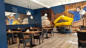 Plenty of tables and a big picture on the wall that gives a pleasant atmosphere to the restaurant. at Dhaba in Vordingborg