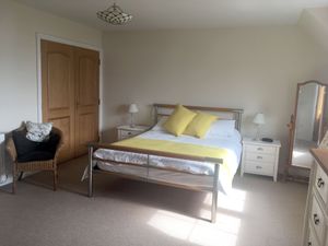 Bedroom with king size bed and ensuite bathroom, and a sea view. at Stonewater House Vegan B&B in Isle Of Arran