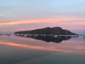 A beautiful June sunset over Holy Isle from Lamlash pier at Stonewater House Vegan B&B in Isle Of Arran