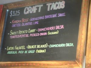 Menu board showing vegan tacos at Screaming Goat in Sarasota