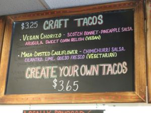 Menu board showing vegan tacos at Screaming Goat in Sarasota