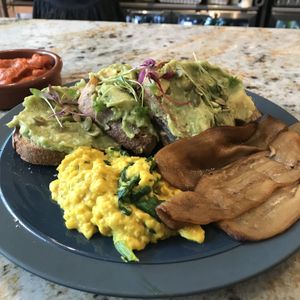 Avocado on sourdough bread with scrambled eggs and aubergine bacon!  at Tell Your Friends in South West London