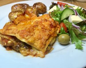 Vegetable and puy lentils lasagna with garlic & herb roasties with Med salad.  at Lil Mama's Vegan Kitchen in Paignton