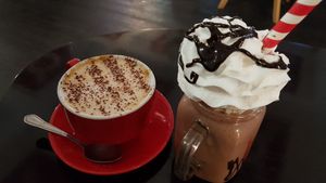 Oat latte and my mega chocolate strawberry smooth loaded with Cream.  at Prana Cafe in Leicester