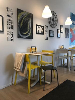 Predominantly white and yellow with fine art on the wall and a large Hergé print.
 at Tuokio in Oulu