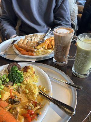 Two full plates with an almond matcha and an oat mocha on the side 😋  at HILTL - Sihlstrasse in Zurich