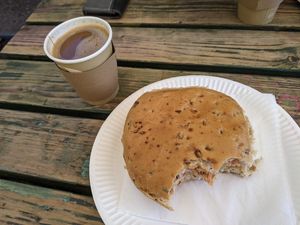 Apologies, started eating it already! Huge sausage bap and coffee with oat milk at Sally's Place - Kiosk in Malvern
