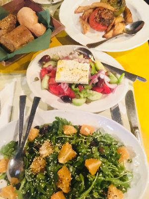 Vegan/non vegan dishes. Salat,sesame, raisins, greens, orange. Stuffed tomatoes at Oikeio in Athens