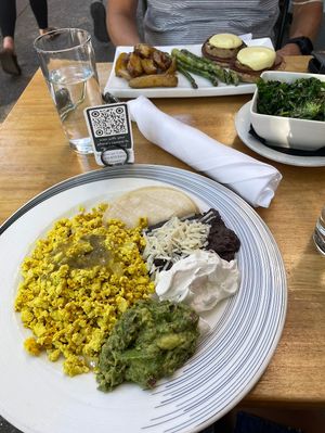 In front Huevos Rancheros, back Eggs Benedict & sauteed kale. at Blossom Restaurant on Columbus in New York City