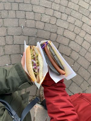 Vegan hot dog with pickled cucumbers (left) and black sheep dog (right)   at Akureyri Hot Dog Stand in Akureyri
