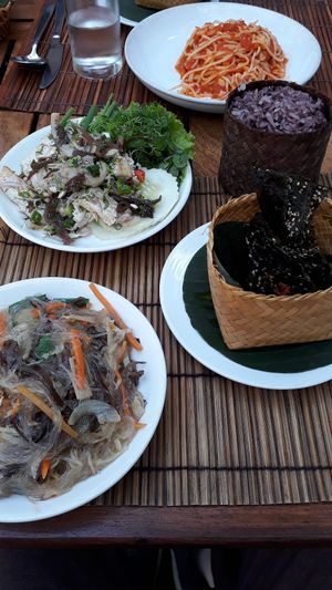 Tofu and mushroom laap, glass noodles with vegetables, sticky rice, river weeds and tomato pasta at Coconut Garden in Luang Prabang