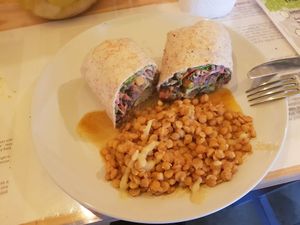 Burger in a wrap, filled with sprouts and mildly curried lentils on the side, tastes go well together, wholesome and healthy at The Sunshine Food Co in Cape Town