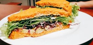 Homemade bread, avocado, cashew cream with herbs, purple cabbage, greens and tomato. at Bateleur in Montevideo